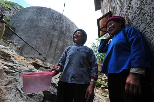 5月7日,在廣西田林縣浪平鄉(xiāng)江垌村,兩位婦女在家庭水柜取水。新華社記者 黃孝邦 攝