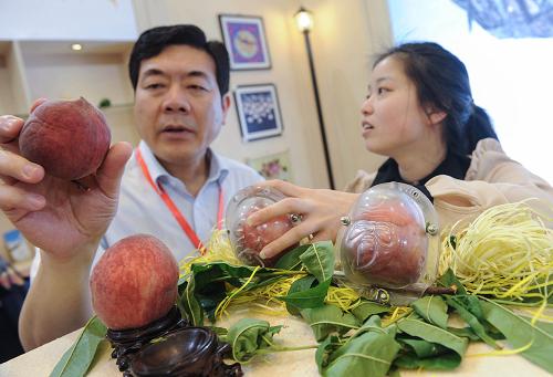 5月15日,來自上海奉賢的工作人員介紹即將上市的壽桃及其生產(chǎn)模具。新華社記者 韓傳號 攝