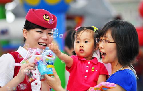6月1日,在天津站候車大廳,“高鐵玫瑰”服務(wù)組成員在和小旅客玩耍。新華社發(fā)(楊寶森 攝)