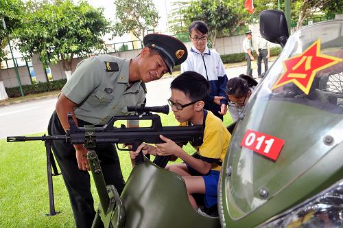 6月1日,駐澳門部隊官兵指導(dǎo)澳門學(xué)生軍事知識。新華社記者 張金加 攝