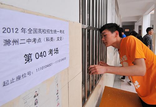 6月6日,一名高考考生在安徽滁州市第二中學(xué)的一處考場外向里張望。6月7日,全國數(shù)百萬考生將迎來高考首日。據(jù)教育部消息,2012年全國普通高校招生報(bào)名總數(shù)為915萬名,比去年減少2%,12個(gè)?。▍^(qū)、市)較去年增加,其中一半在西部地區(qū)。全國平均錄取率為75%,比去年增加近3個(gè)百分點(diǎn)。今年高考共設(shè)立7300個(gè)考點(diǎn),31萬個(gè)考場。有26個(gè)省高考全部采用標(biāo)準(zhǔn)化考場;另外5個(gè)省份部分使用標(biāo)準(zhǔn)化考場。共有16個(gè)省份繼續(xù)實(shí)行自主命題。新華社發(fā)(王家國 攝)
