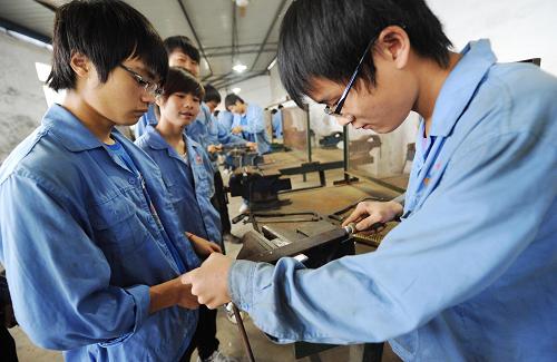 6月6日,重慶工業(yè)技師學(xué)院數(shù)控技術(shù)專(zhuān)業(yè)的中職學(xué)生在進(jìn)行鉗工實(shí)訓(xùn)。重慶市永川區(qū)是重慶規(guī)劃建設(shè)的重點(diǎn)職業(yè)教育基地,轄區(qū)內(nèi)現(xiàn)有18所職業(yè)教育學(xué)校,在校學(xué)生11.3萬(wàn)人,每年為社會(huì)培養(yǎng)3萬(wàn)多名技能型人才,就業(yè)率穩(wěn)居96%以上。2009年至2011年底,永川區(qū)實(shí)施針對(duì)本地人的免費(fèi)中職教育,投入3300多萬(wàn)元,培訓(xùn)了2萬(wàn)余名永川籍中職學(xué)生。新華社記者 李健 攝