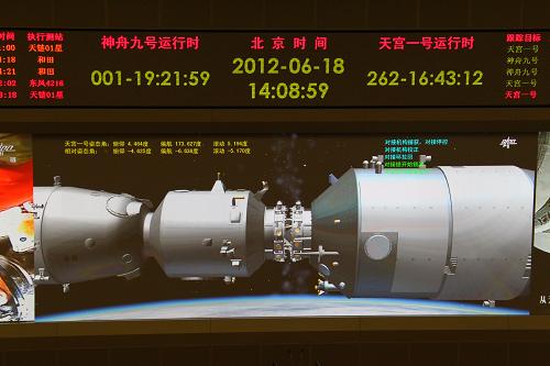 6月18日拍攝的北京航天飛控中心大屏幕顯示的神九飛船與天宮一號交會對接的畫面。 新華社記者查春明攝