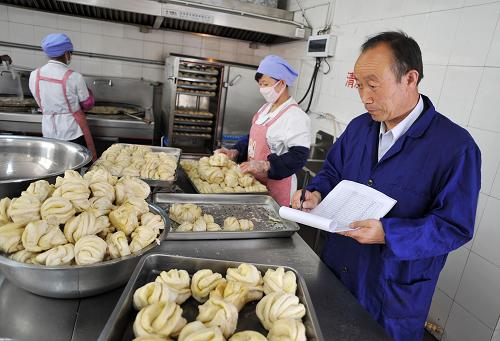 在寧夏固原市原州區(qū)張易鎮(zhèn)中心小學(xué)的食堂內(nèi),學(xué)校的食堂管理員正在登記主食的用量(6月13日攝)。新華社記者 彭昭之 攝