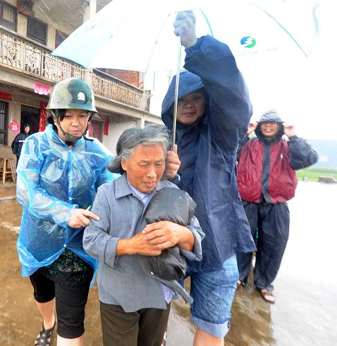 8月7日,在浙江省臺州市路橋區(qū)金清鎮(zhèn),一位老人在工作人員的幫助下安全轉移。新華社發(fā)(王保初 攝)