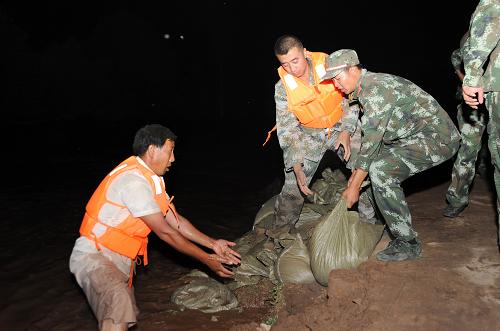 8月26日,消防官兵正在對(duì)堤壩進(jìn)行加固。連日來(lái),由于甘肅多地遭遇強(qiáng)降雨襲擊,黃河水位甘肅段急劇上漲,為此劉家峽水庫(kù)加大泄洪量,導(dǎo)致沿線多處黃河堤壩出現(xiàn)險(xiǎn)情。8月26日,黃河甘肅靖遠(yuǎn)段約50公里河堤出現(xiàn)56處決堤險(xiǎn)情,直接威脅到9個(gè)鄉(xiāng)鎮(zhèn)30余個(gè)村莊的安全。險(xiǎn)情出現(xiàn)后,甘肅省消防總隊(duì)立即啟動(dòng)應(yīng)急救援機(jī)制,調(diào)動(dòng)全省200余名官兵趕赴現(xiàn)場(chǎng)展開搶險(xiǎn)救援。截至27日凌晨2時(shí),消防官兵已經(jīng)完成營(yíng)防村沿河堤壩的加固堵漏工作。新華社發(fā)(師永紅攝)