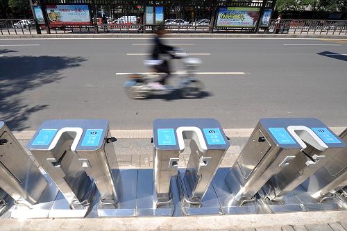 9月14日,一位市民從山西省太原市新建南路公共自行車租賃點(diǎn)旁經(jīng)過。新華社記者 詹彥 攝
