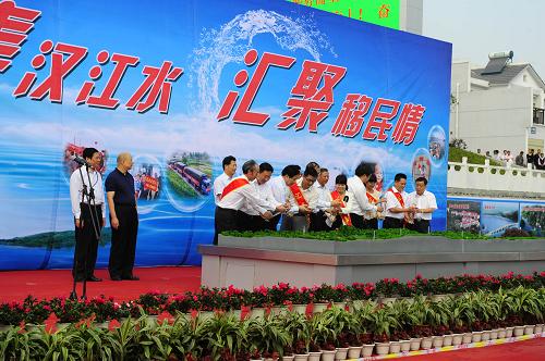 9月18日,在移民搬遷結(jié)束儀式上,庫區(qū)移民和移民干部代表將丹江口水庫里的清水注入南水北調(diào)工程縮微模型。新華社記者 郝同前 攝