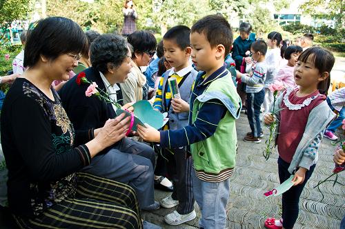 10月16日,孩子們把賀卡和鮮花送給社區(qū)老人。新華社記者 徐昱 攝
