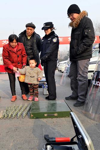 1月10日,濟(jì)南市公安局歷城區(qū)分局民警在向市民介紹“110”警用裝備。新華社記者 朱崢 攝