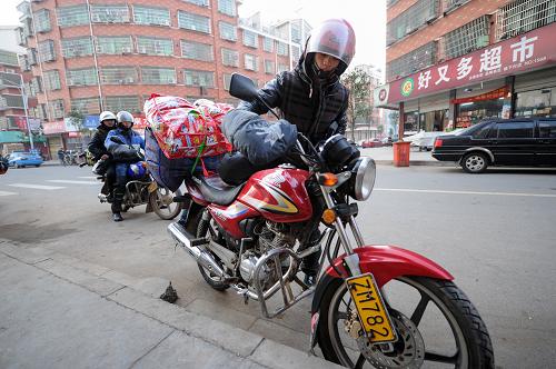 1月30日,趙雨兵(前)與幾位老鄉(xiāng)一起跨上摩托車,準(zhǔn)備出發(fā)踏上回家的路。新華社記者 鞠煥宗 攝