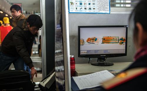 2月19日,安檢人員通過掃描機(jī)器檢查旅客的行李。新華社記者 程敏 攝