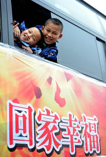2月1日,在安徽阜陽火車站停車場,兩名農(nóng)民工子女乘坐免費大巴。在2月1日至2月7日活動期間,阜陽市下轄縣(市)各提供6臺45座大巴車,在阜陽火車站臨時停車場免費接返鄉(xiāng)人員回家過年。 新華社記者 劉軍喜 攝