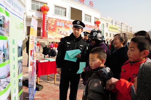 2月22日,在甘肅省蘭州市皋蘭縣文化廣場舉行的農(nóng)村廟會上,蘭州鐵路公安處蘭州東車站派出所的民警王康在為群眾講解鐵路安全常識。新華社記者 范培珅 攝