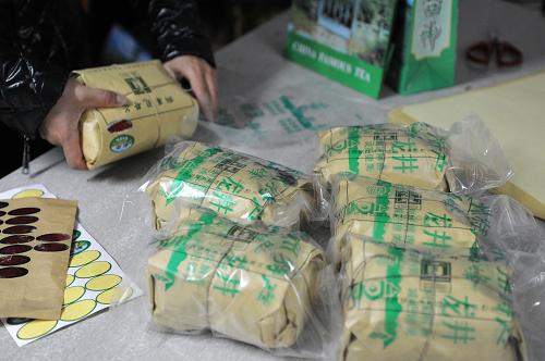 3月25日,在杭州市西湖區(qū)龍井村,一位茶農(nóng)正在把用牛皮紙和宣紙包裝的西湖龍井茶進(jìn)行塑封包裝。據(jù)了解,在杭州西湖龍井產(chǎn)茶區(qū),往年走俏的高檔紅木、龍泉青瓷包裝茶葉禮盒今年大多滯銷,取而代之的是以宣紙和牛皮紙包裝并以塑料袋密封的“簡易包裝”。據(jù)茶農(nóng)介紹,宣紙吸潮、牛皮紙防潮,放入石灰缸里,這樣適合茶葉的保存,也更經(jīng)濟(jì)實惠。 新華社記者 鞠煥宗 攝