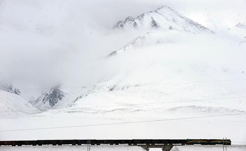 7月9日,一列進(jìn)藏貨車駛經(jīng)昆侖雪山。新華社記者 侯德強(qiáng) 攝