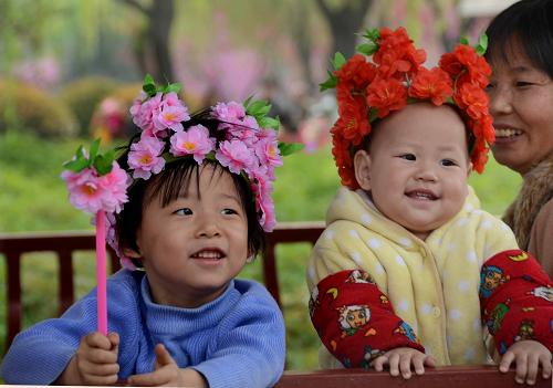 兩名頭戴牡丹花帽的幼童,在洛陽市的一個公園玩耍(2013年4月3日攝)。“啟動實(shí)施一方是獨(dú)生子女的夫婦可生育兩個孩子的政策”,引來社會各界關(guān)注。據(jù)河南省人口計(jì)生委的調(diào)查,全省單獨(dú)夫妻近幾年開始陸續(xù)進(jìn)入婚育期。按戶籍人口口徑、女方22歲結(jié)婚測算,河南目前約有單獨(dú)夫妻100萬對,預(yù)計(jì)今后一個時期內(nèi),每年將會新增加15萬多對單獨(dú)夫妻。初步測算,在政策平穩(wěn)實(shí)施(消除生育堆積以后)的情況下,平均每年多生的人口數(shù)在5萬至8萬,每年出生率提高0.5—0.75個千分點(diǎn)。 新華社記者 王頌 攝