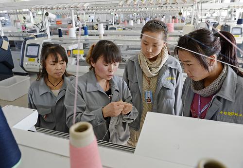 寧夏靈武市涇靈新村農(nóng)民在移民村里一家羊絨制品加工企業(yè)學習紡織技術(shù)(12月11日攝)。 新華社記者 王鵬 攝