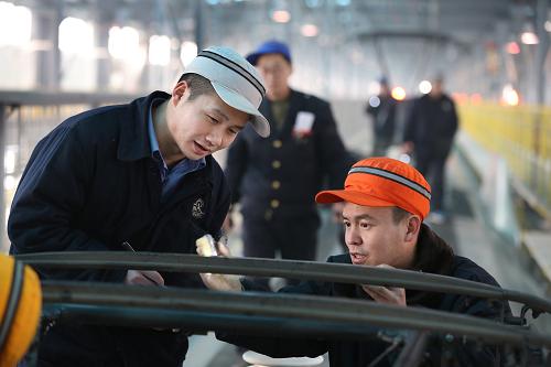 1月14日,鄭州鐵路局鄭州車輛段職工在清掃動(dòng)車組受電弓受電滑板。新華社發(fā) 祝慶 攝