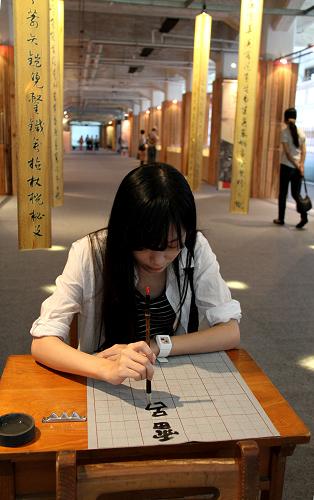 9月4日,一名參觀者在“漢字藝術(shù)節(jié)”上練習毛筆書法。新華社記者 樊浩宇 攝