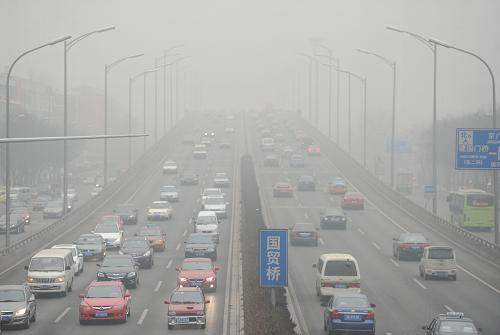 1月23日,車輛緩慢行駛在大霧彌漫的北京東三環(huán)國貿(mào)橋上。當(dāng)日,北京大霧彌漫。北京市氣象局在早晨6時15分發(fā)布霾黃色預(yù)警,預(yù)計當(dāng)天白天全市大部分地區(qū)將出現(xiàn)能見度小于3000米的霾,空氣污濁,請市民注意防范。新華社記者 羅曉光 攝
