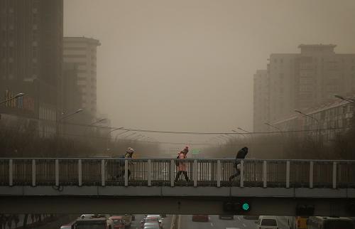 2月28日11時左右,行人在北京市南二環(huán)附近的天橋上頂風前行。新華社發(fā)(萬象 攝)