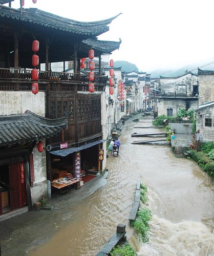 6月27日,在江西省婺源縣李坑景區(qū),暴雨引發(fā)的山洪涌上路面。 新華社發(fā)(張衛(wèi)國(guó) 攝)