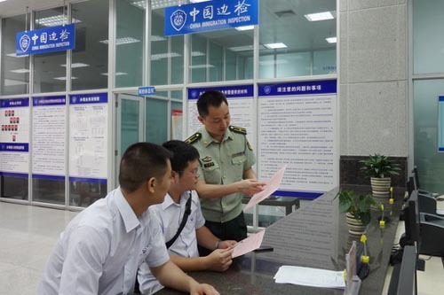 圖為該站業(yè)務(wù)科科長楊通勇在申報大廳向兩名旅客發(fā)放評選測評表