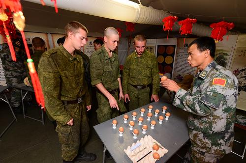 8月7日,在俄羅斯中部軍區(qū)切巴爾庫爾合同訓(xùn)練場,中方參演人員向俄方官兵展示出自戰(zhàn)士之手的蛋雕作品。新華社發(fā)(譚長俊攝)