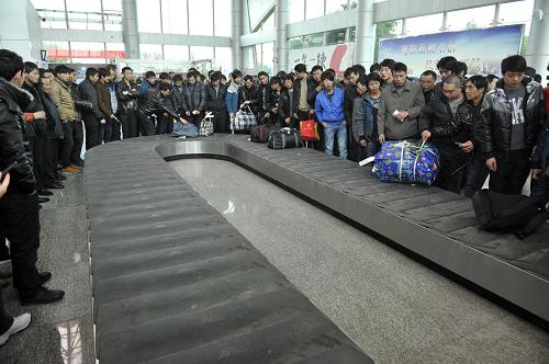 1月29日,乘坐“返鄉(xiāng)專機(jī)”回家過年的農(nóng)民工在機(jī)場等待領(lǐng)取行李。當(dāng)日,上海至貴州興義直飛航線正式開通,96名興義籍農(nóng)民工乘坐航線開通后的首次航班回到故鄉(xiāng)。為讓農(nóng)民工返鄉(xiāng)之路更便利、更省錢,貴州黔西南州政府在春運(yùn)期間通過政府補(bǔ)助的方式,幫助黔西南州籍農(nóng)民工和高校學(xué)生購買特價(jià)機(jī)票,方便他們返鄉(xiāng)過年。農(nóng)民工和大學(xué)生購買北京至興義、上海至興義兩個航線的往返機(jī)票都將享受2折優(yōu)惠價(jià)格。據(jù)了解,本次乘坐“專機(jī)”返鄉(xiāng)的96名農(nóng)民工中,絕大部分是首次乘坐飛機(jī)。新華社記者 歐東衢 攝