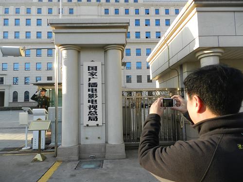 3月22日,一位外地廣電職工專程在國家廣播電影電視總局門牌前拍照留影。當日,國家新聞出版廣電總局掛牌。根據(jù)國務(wù)院公布的機構(gòu)改革和職能轉(zhuǎn)變方案,新聞出版總署、廣電總局將整合組建成國家新聞出版廣電總局,不再保留國家廣播電影電視總局。新華社發(fā)(王振 攝)