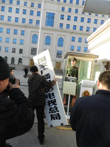3月22日,工作人員將國家廣播電影電視總局的門牌摘下。新華社發(fā)(王振 攝)