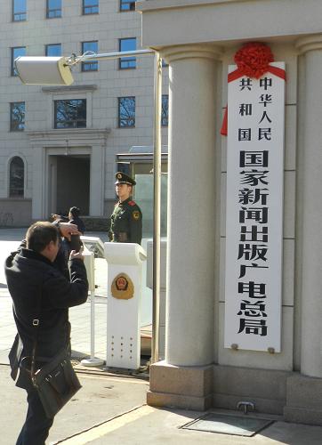 3月22日,一名游客在國家新聞出版廣電總局揭牌現(xiàn)場拍照。新華社發(fā)(王振 攝)