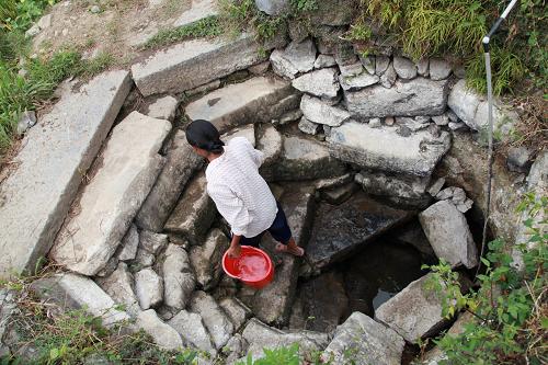 8月3日,廣西壯族自治區(qū)全州縣東山瑤族鄉(xiāng)坪香村一名女子從一口已快干涸的水井提水回家。新華社發(fā)(王滋創(chuàng) 攝)