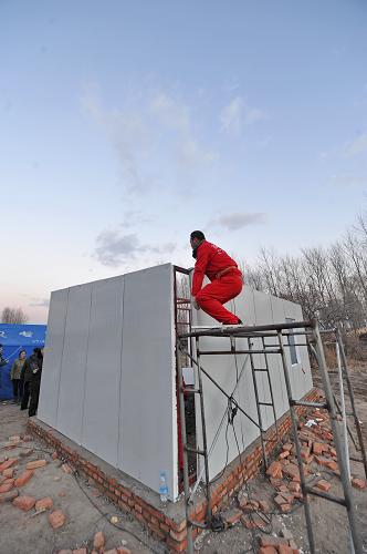 11月6日,工人在建設(shè)過渡安置彩鋼房。新華社記者 張楠 攝