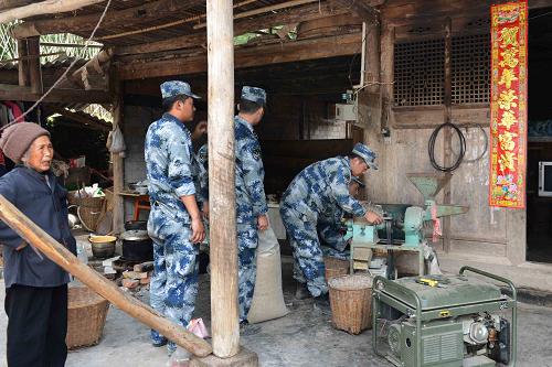 4月25日,成空導(dǎo)彈某旅官兵發(fā)動機器開始為楊國珍老人家打米。新華社發(fā)(李驥 攝)