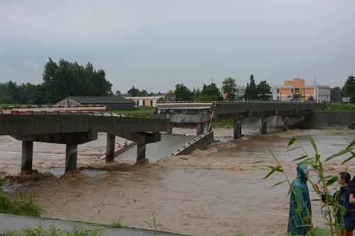 7月10日,四川德陽(yáng)綿竹市新市鎮(zhèn)射水河上的觀魚(yú)新橋橋面落入水中。7月10日8時(shí)許,四川德陽(yáng)綿竹市新市鎮(zhèn)射水河上的觀魚(yú)新橋被洪水沖毀,由于當(dāng)?shù)匾言跇蛎嫣?個(gè)半小時(shí)前對(duì)該橋?qū)嵭芯?,禁止過(guò)往車(chē)輛和行人通行,因此沒(méi)有造成人員傷亡。觀魚(yú)新橋是繼9日綿竹市綿遠(yuǎn)河牛鼻子大橋和興隆拱星大橋后該市第三座被洪水沖毀的大橋。新華社發(fā)(王平 攝)