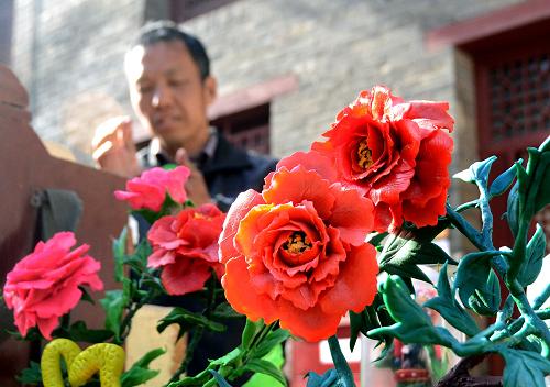 4月11日,一位民間藝人在廟會(huì)上制作面塑工藝品“洛陽牡丹”。新華社記者 王頌 攝