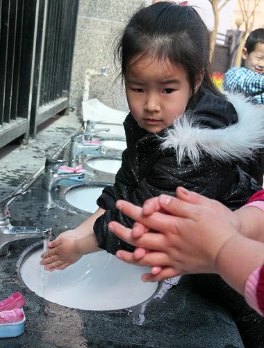 4月8日,在上海金山區(qū)新城幼兒園,幼兒在老師的指導(dǎo)下學(xué)習(xí)正確的洗手方法。新華社發(fā)(莊毅 攝)