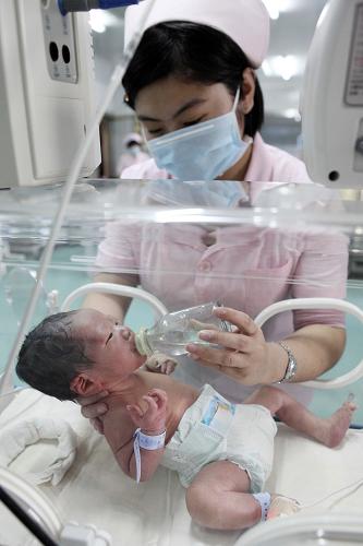 2月11日,在江蘇省贛榆縣人民醫(yī)院新生兒重癥監(jiān)護室,一名護士在給患兒喂水。新華社發(fā)(司偉 攝)