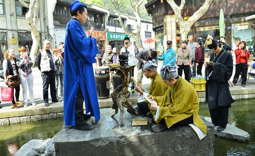 4月12日,游客和市民在觀(guān)看演員表演陸羽講《茶經(jīng)》的情景劇。新華社發(fā)(龍巍 攝)