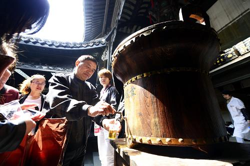 4月12日,游客在杭州河坊街上一家老字號(hào)藥房里品嘗免費(fèi)藥茶。新華社發(fā)(龍巍 攝)