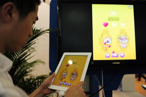 6月15日,一名參展商在展示自主研發(fā)的APP應(yīng)用程序。新華社記者 潘昱龍 攝