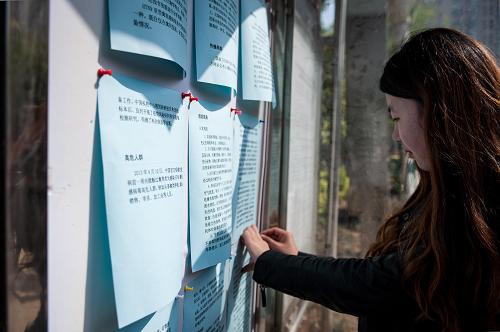 4月12日,在南京市建鄴區(qū)興隆街道某小區(qū),一位小區(qū)工作人員在宣傳欄前張貼禽流感防控知識(shí)宣傳單。新華社記者 李芒茫 攝