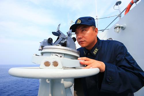 7月9日,在“海上聯(lián)合—2013”中俄海上聯(lián)演中,中國海軍沈陽艦艦長張長龍上校觀察海上目標(biāo)。新華社記者查春明攝