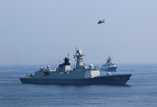 7月9日,在“海上聯(lián)合—2013”中俄海上聯(lián)演中,中國海軍軍艦和艦載直升機(jī)參加實(shí)兵演練。新華社記者查春明攝
