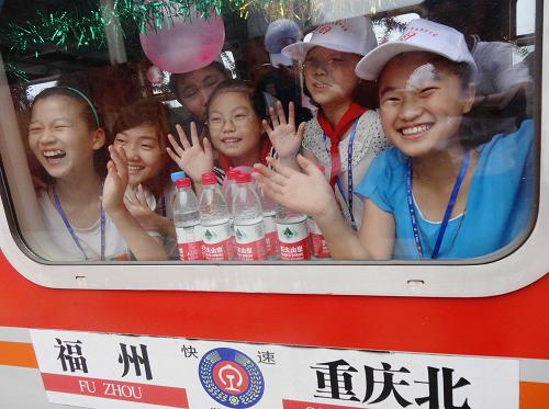 7月9日,參加“留守學(xué)生圓夢親情列車行動”的留守學(xué)生,在四川渠縣火車站登上開往福州的列車后揮手告別送行的人們。新華社發(fā)(鄧良奎 攝)