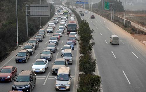 2月15日,在長張高速長沙西收費站附近,進出長沙方向的車道上車輛數(shù)量形成鮮明對比。新華社記者 李尕攝