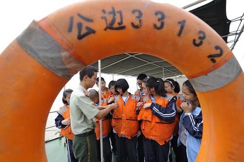 6月12日,浙江溫州飛云江邊防民警給駐地學(xué)生講解救生衣使用常識。新華社發(fā)(蔡寬元 攝)