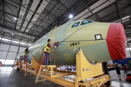 6月13日,空客天津總裝線工作人員在檢查運(yùn)抵的A320系列飛機(jī)大部件,部件上標(biāo)有該總裝線第100架飛機(jī)的“100”字樣。新華社發(fā)(賈可 攝)